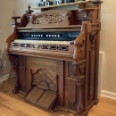 Vintage Burdett brand ornate Victorian pump organ of solid walnut with beautiful pull-stops, music stand, pull-down cover, and lots of curvy designs all around